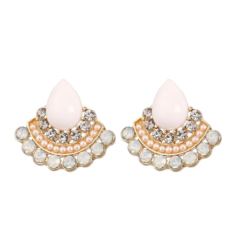 Close-up of silver retro fan-shaped earrings with opal and rhinestone decoration on a needle post.