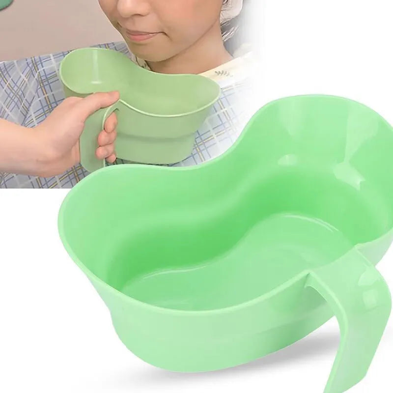 Green plastic nursing cup with an angled spout for bedridden patient drinking.