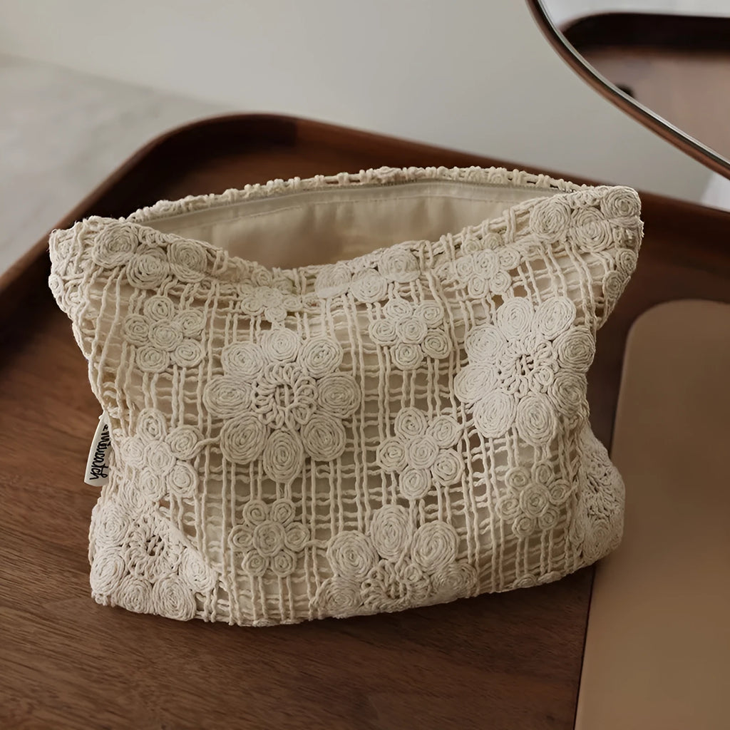 Handmade crocheted corduroy cosmetic bag with hollow flower embroidery and floral cut-out details.