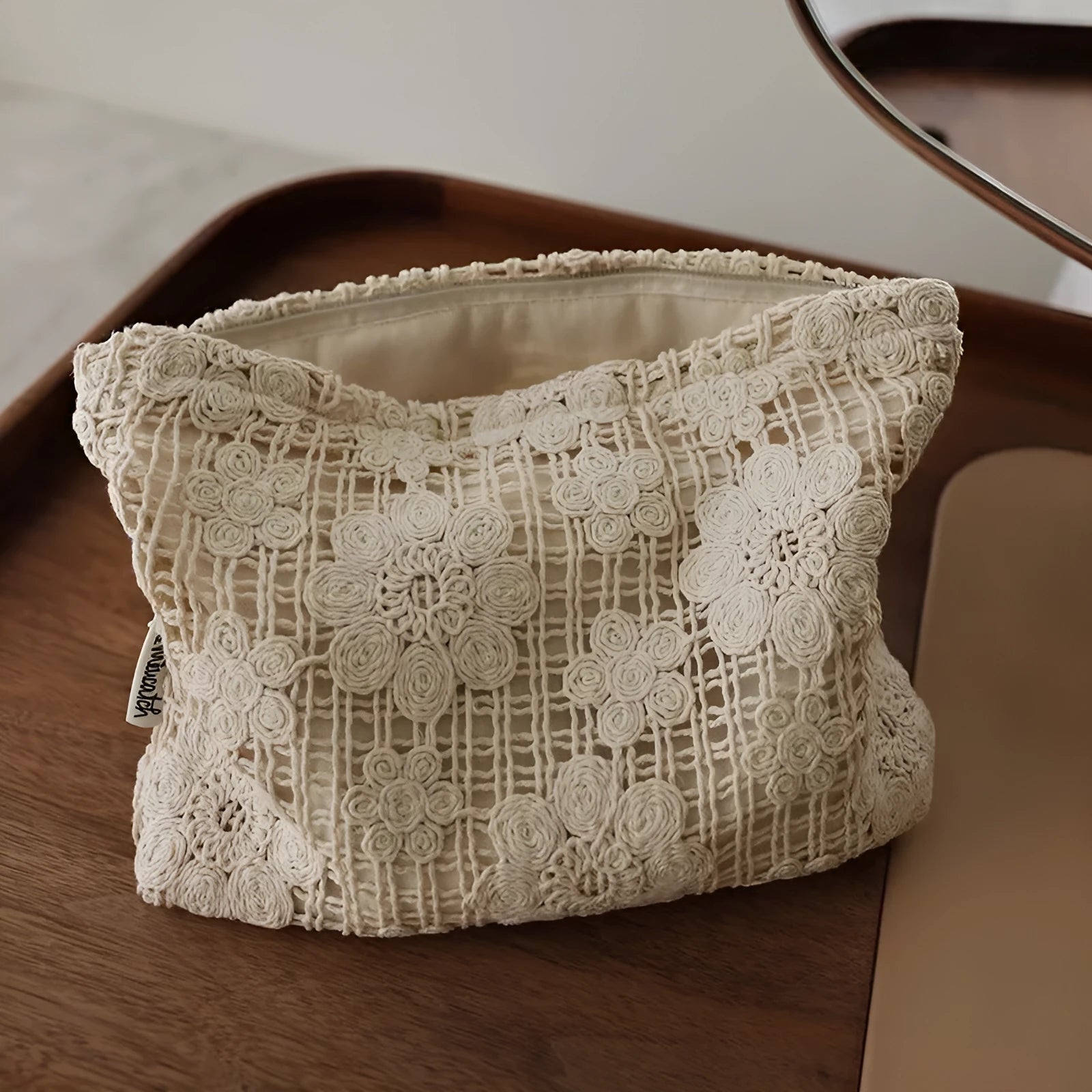Handmade crocheted corduroy cosmetic bag with hollow flower embroidery and floral cut-out details.