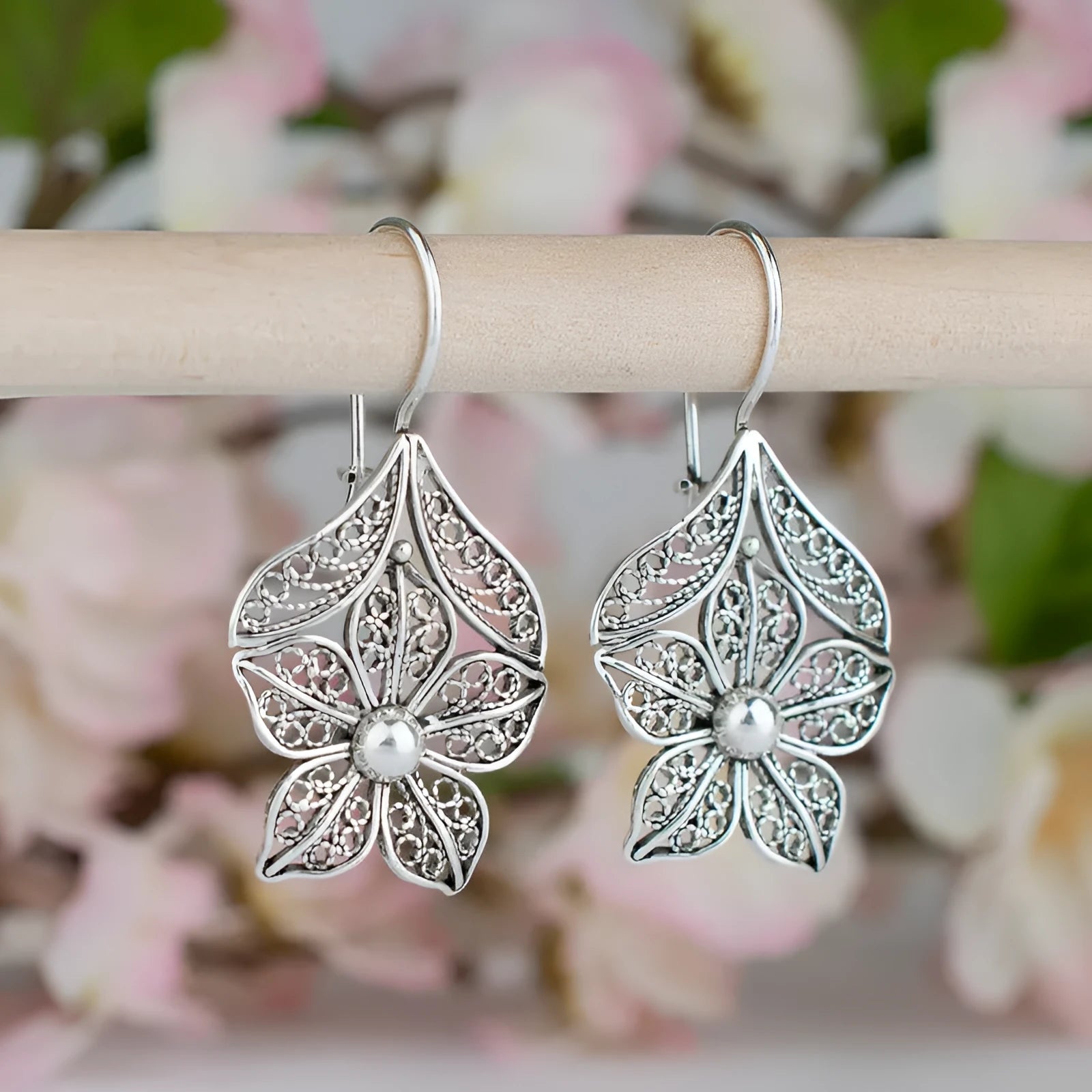 Women's retro simple hollow flower leaf-shaped earrings in silver alloy, a pair of drop earrings with hollow metal design