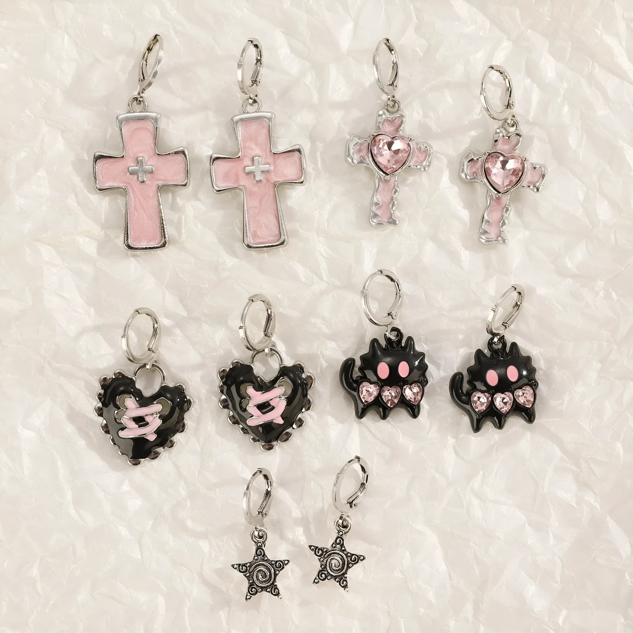 Women's alloy drop earrings featuring cross, heart, and cat charms in white, black, and antique silver finishes.