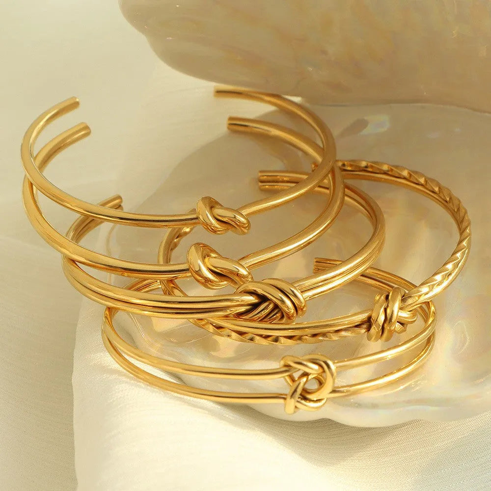 Women's stainless steel knotted C-shaped open double-layer bracelet in gold or silver tone.