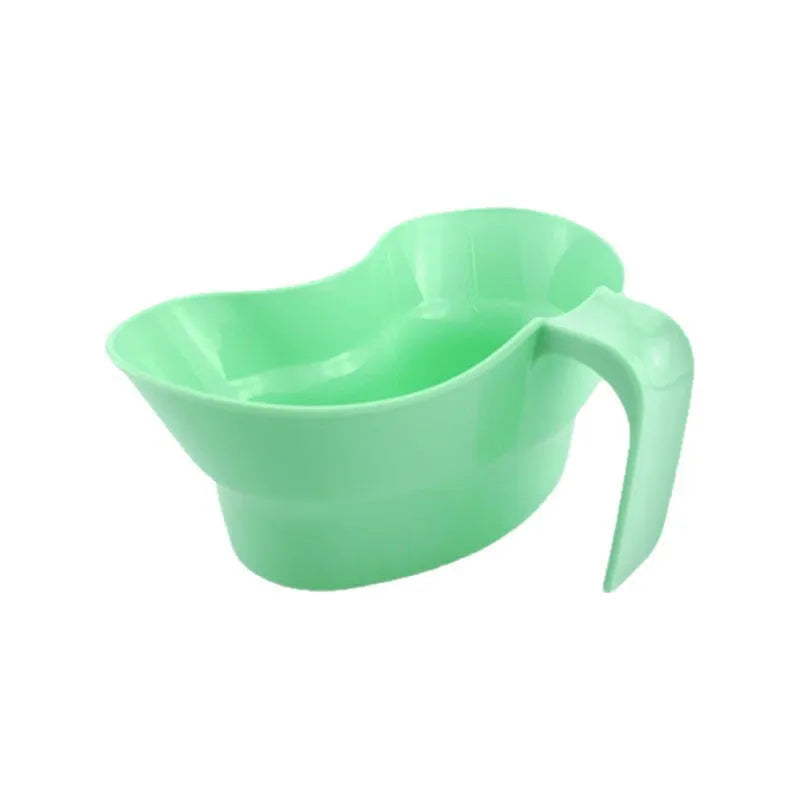 Green plastic nursing cup with an angled spout for bedridden patient drinking.