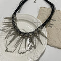 Women's casual leather necklace with a winding tassel, round beads, and silver rivet details.
