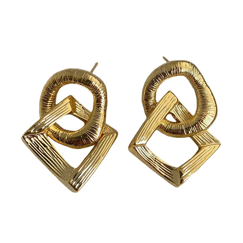 A pair of geometric circle drop earrings with a gold electroplated finish, showing a 3.4cm pendant length.