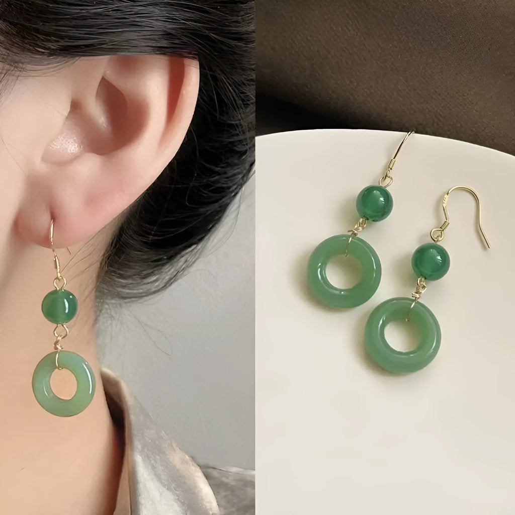 Green geometric peace buckle shape earrings with jade design on zinc alloy background