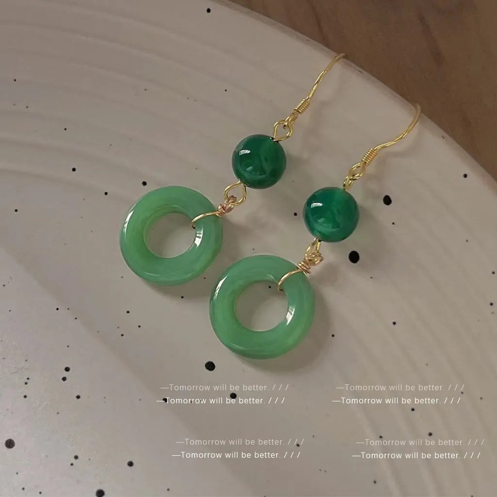 Green geometric peace buckle shape earrings with jade design on zinc alloy background