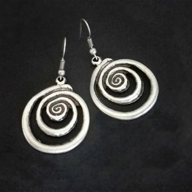 Silver geometric spiral earrings with distressed finish on white background