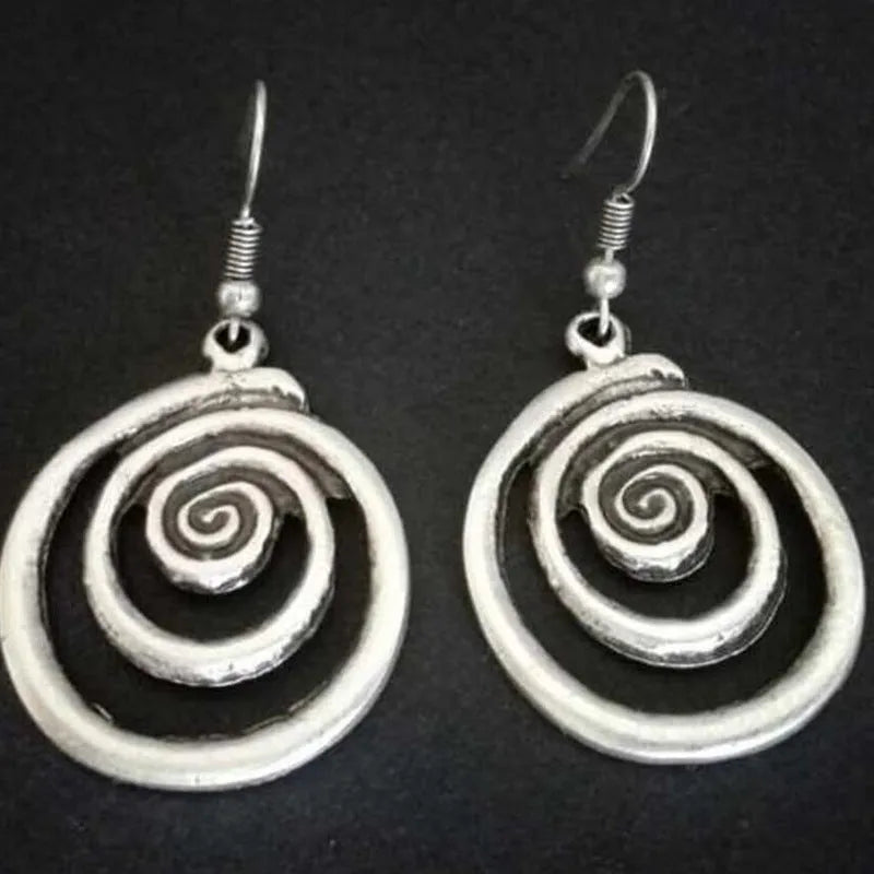 Silver geometric spiral earrings with distressed finish on white background