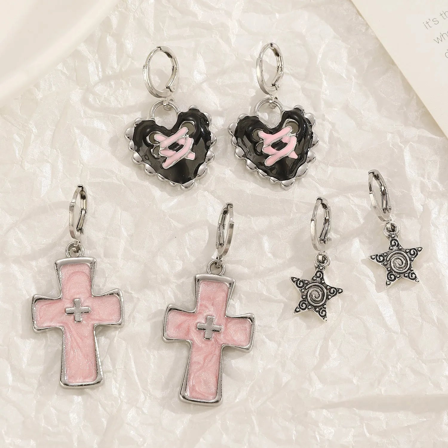 Women's alloy drop earrings featuring cross, heart, and cat charms in white, black, and antique silver finishes.
