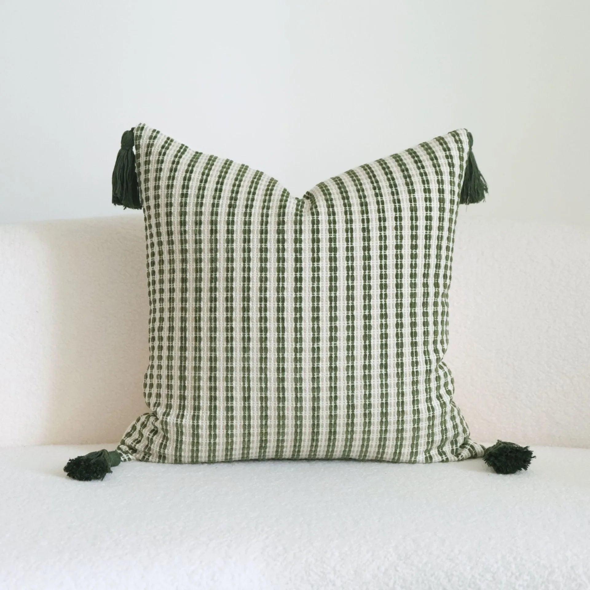 Green cotton and linen tassel hotel sample pillow with botanical patterns on a brushed fabric case