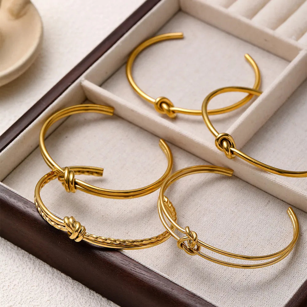 Women's stainless steel knotted C-shaped open double-layer bracelet in gold or silver tone.