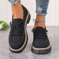 Black plus size women's loafers with a tassel and bowknot decoration on the low-cut upper.