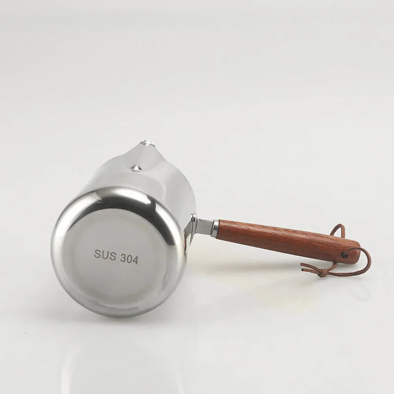 Garland stainless steel coffee milk jug with wooden handle, showing interior volume scale markings.