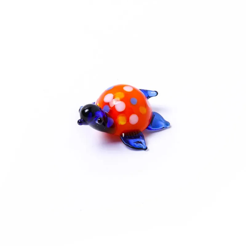 Geometric glass turtle sculpture ornament in a modern style on a wooden desktop.