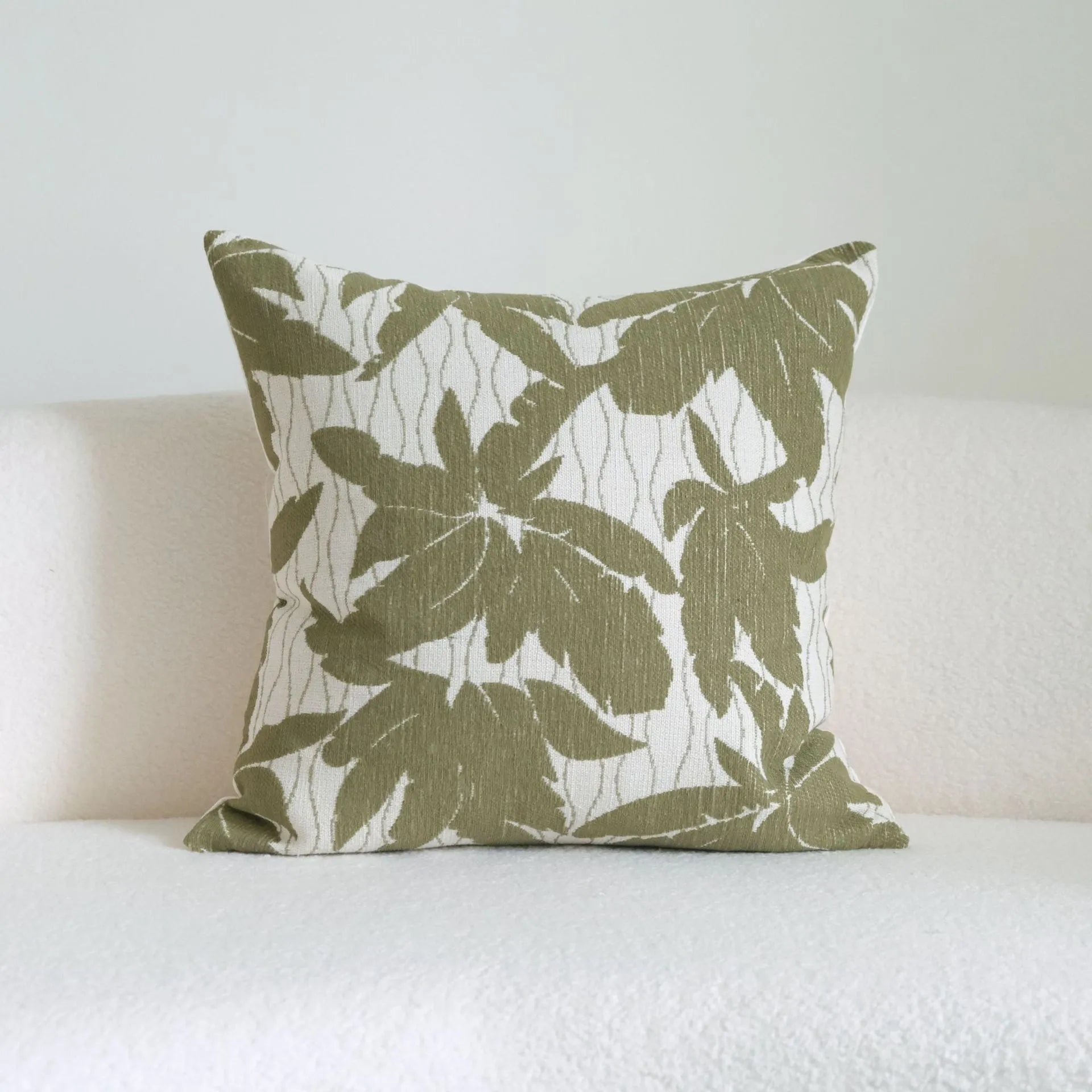 Green cotton and linen tassel hotel sample pillow with botanical patterns on a brushed fabric case