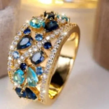 Women's round hollow fashion ring in copper with gold or platinum plating and blue or white accents