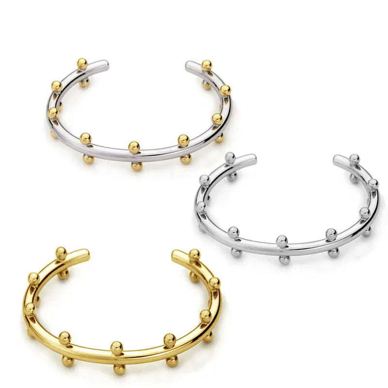 Stainless steel C-shaped bean bead bracelet with textured rivet finish on an alloy chain.