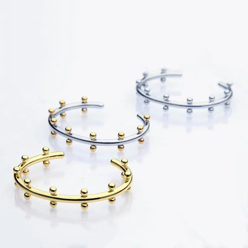 Stainless steel C-shaped bean bead bracelet with textured rivet finish on an alloy chain.