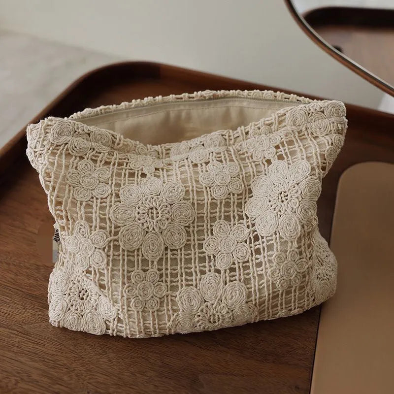 Handmade crocheted corduroy cosmetic bag with hollow flower embroidery and floral cut-out details.