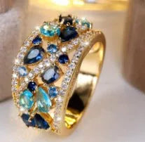 Women's round hollow fashion ring in copper with gold or platinum plating and blue or white accents