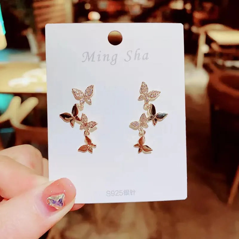 Women's copper butterfly drop earrings with four-element design and gold colour finish