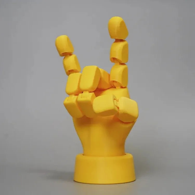 Yellow 3D printed hand ornament with movable joints and detailed sculpting