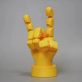 Yellow 3D printed hand ornament with movable joints and detailed sculpting