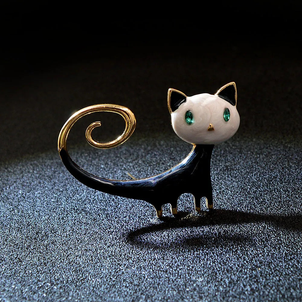 White and orange alloy cat brooch with a painted tailing up kitty design.
