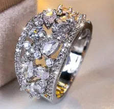 Women's round hollow fashion ring in copper with gold or platinum plating and blue or white accents