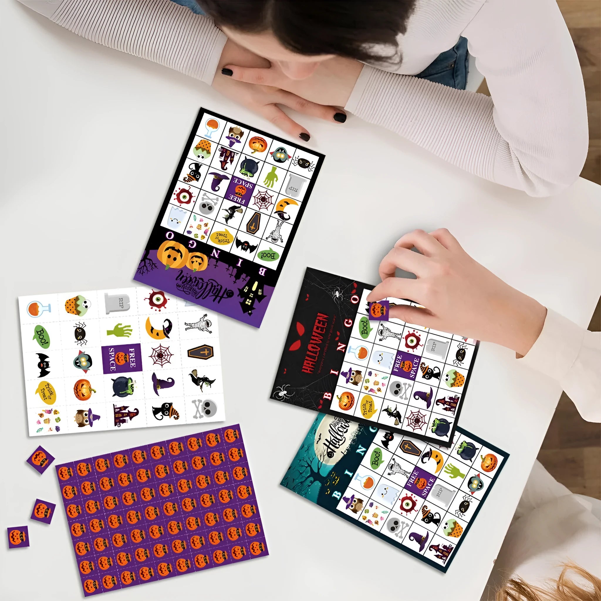 Halloween pumpkin bingo game cards on a table, paper set measuring 13x18 cm
