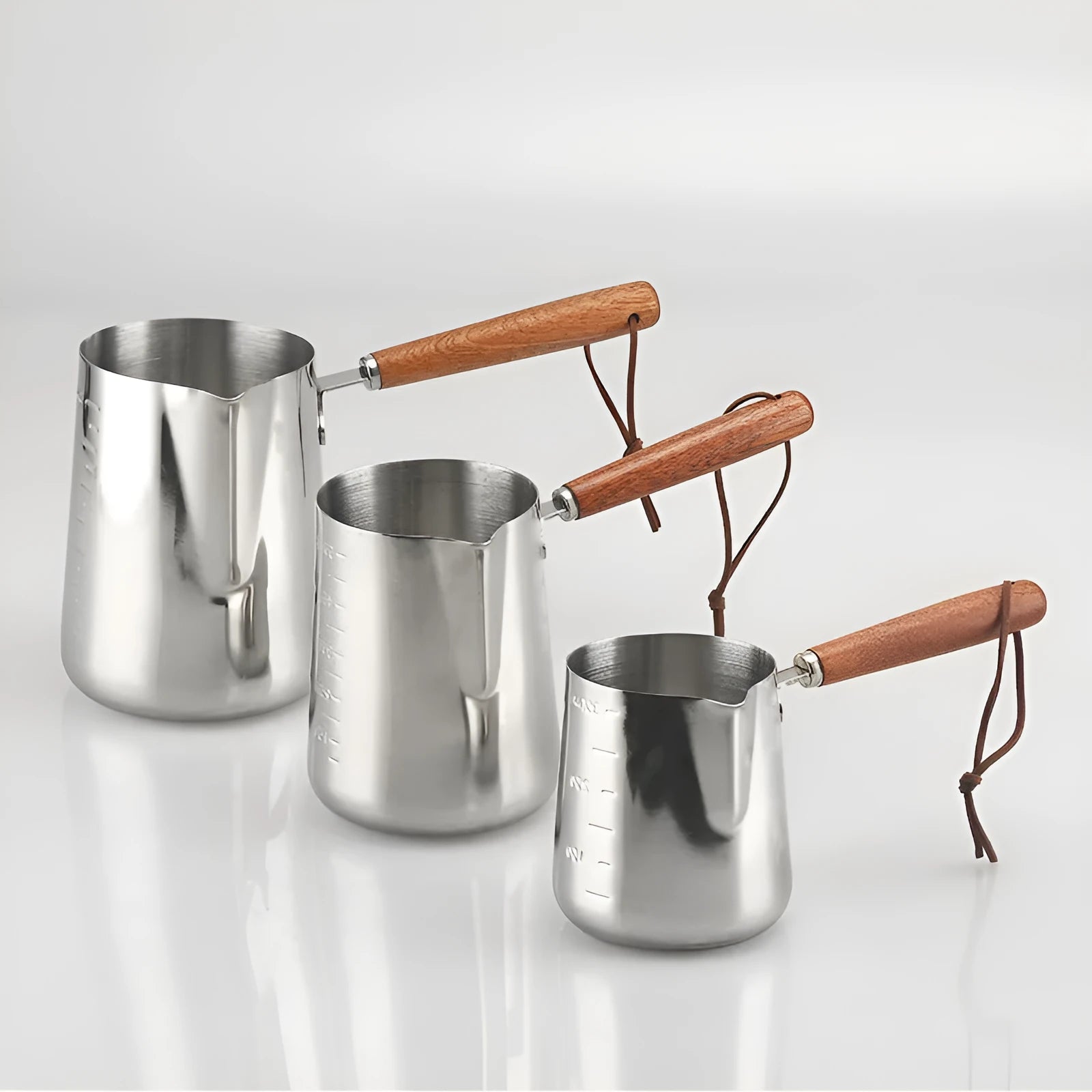 Garland stainless steel coffee milk jug with wooden handle, showing interior volume scale markings.