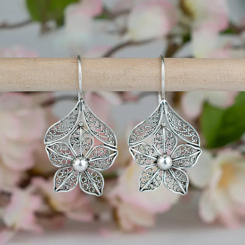 Women's retro simple hollow flower leaf-shaped earrings in silver alloy, a pair of drop earrings with hollow metal design