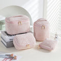 Four cube-style polyester makeup bags in coordinating colours