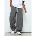 Men's straight leg casual trousers in black with a drawstring waist, laid flat.