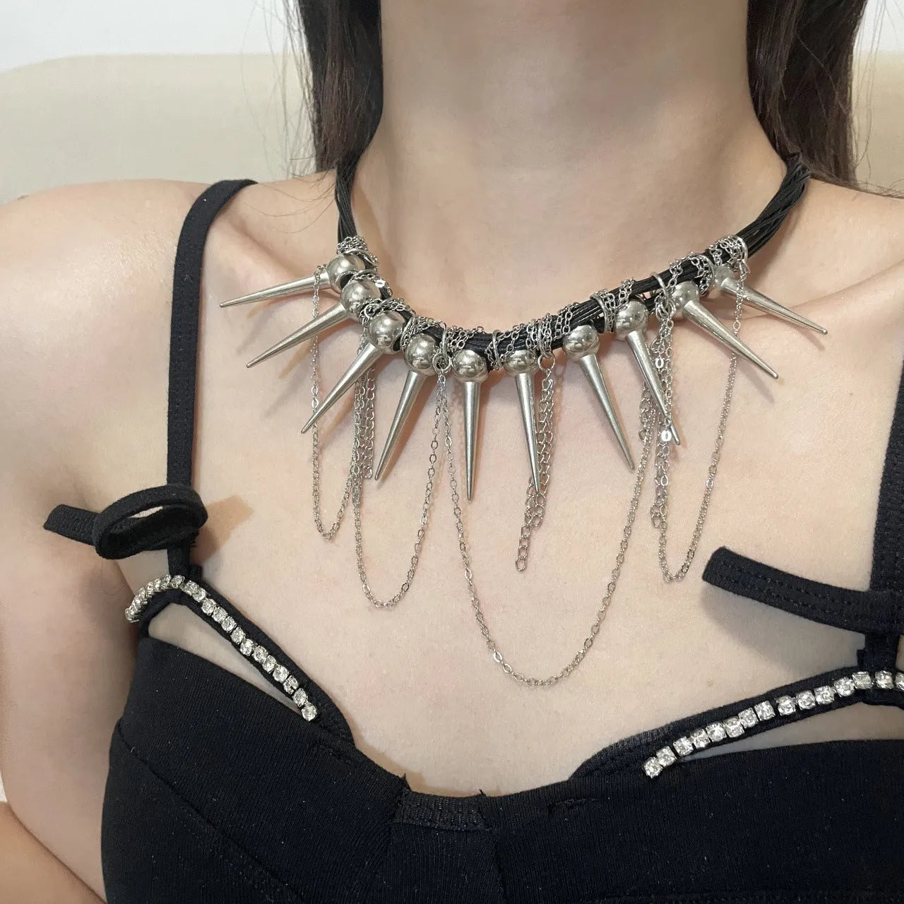 Women's casual leather necklace with a winding tassel, round beads, and silver rivet details.