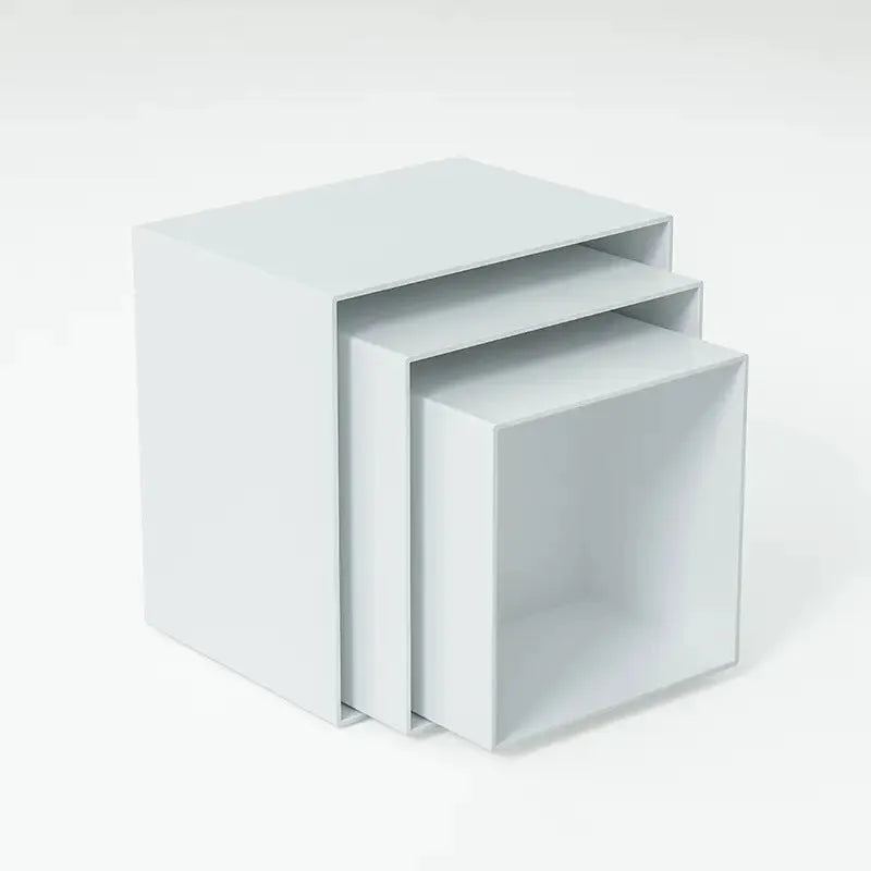 Set of six white plastic cube dessert stands in heights from 3cm to 8cm on a table.