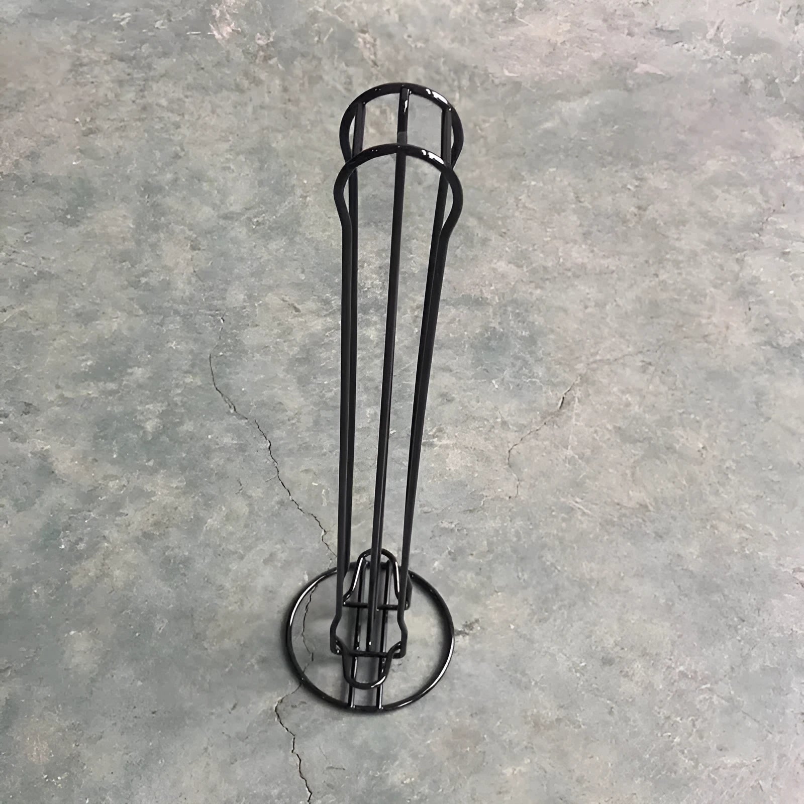 Black wrought iron coffee capsule storage rack holding 20 capsules on display shelves