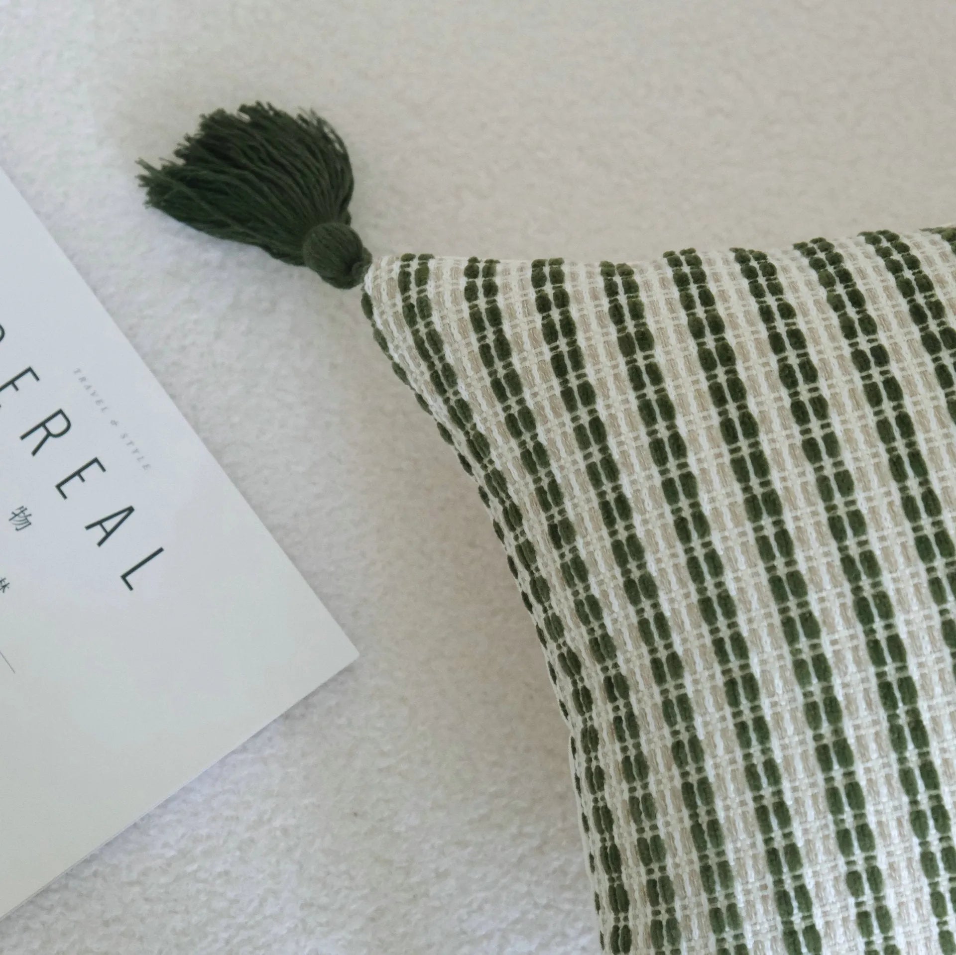 Green cotton and linen tassel hotel sample pillow with botanical patterns on a brushed fabric case