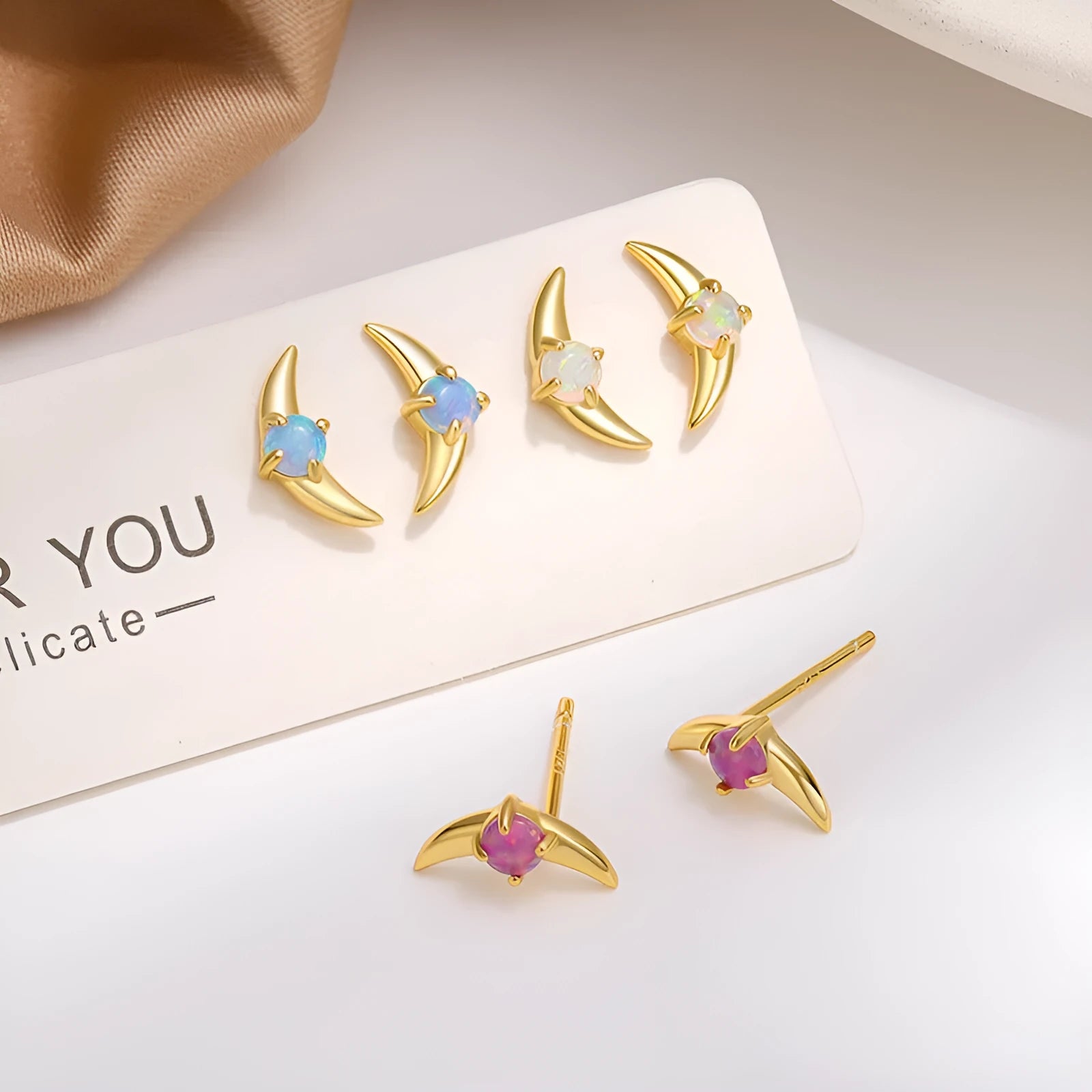 A pair of women's geometric earrings in 925 silver with a blue stone and gold electroplated finish.