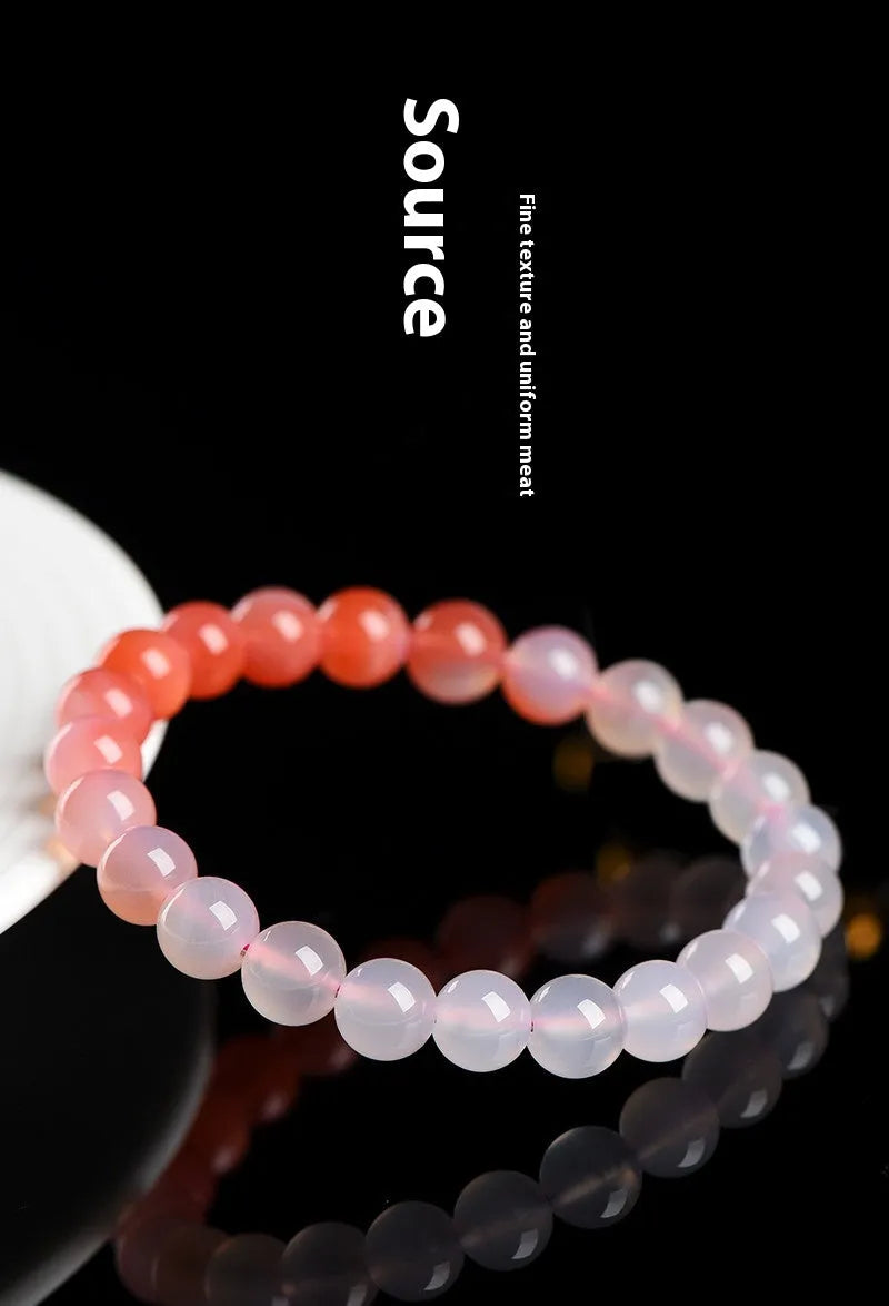Natural gradient Yanyuan agate bracelet with spherical beads on a white background.
