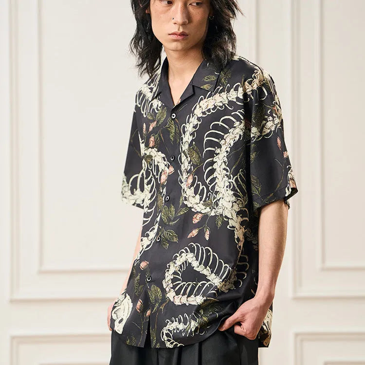 Short sleeve loose-fit shirt with a Cuban collar and a printed snake bone floral pattern.