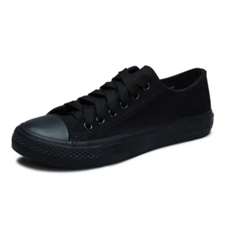 Solid colour women's canvas lace-up flats in black, shown on a white background.