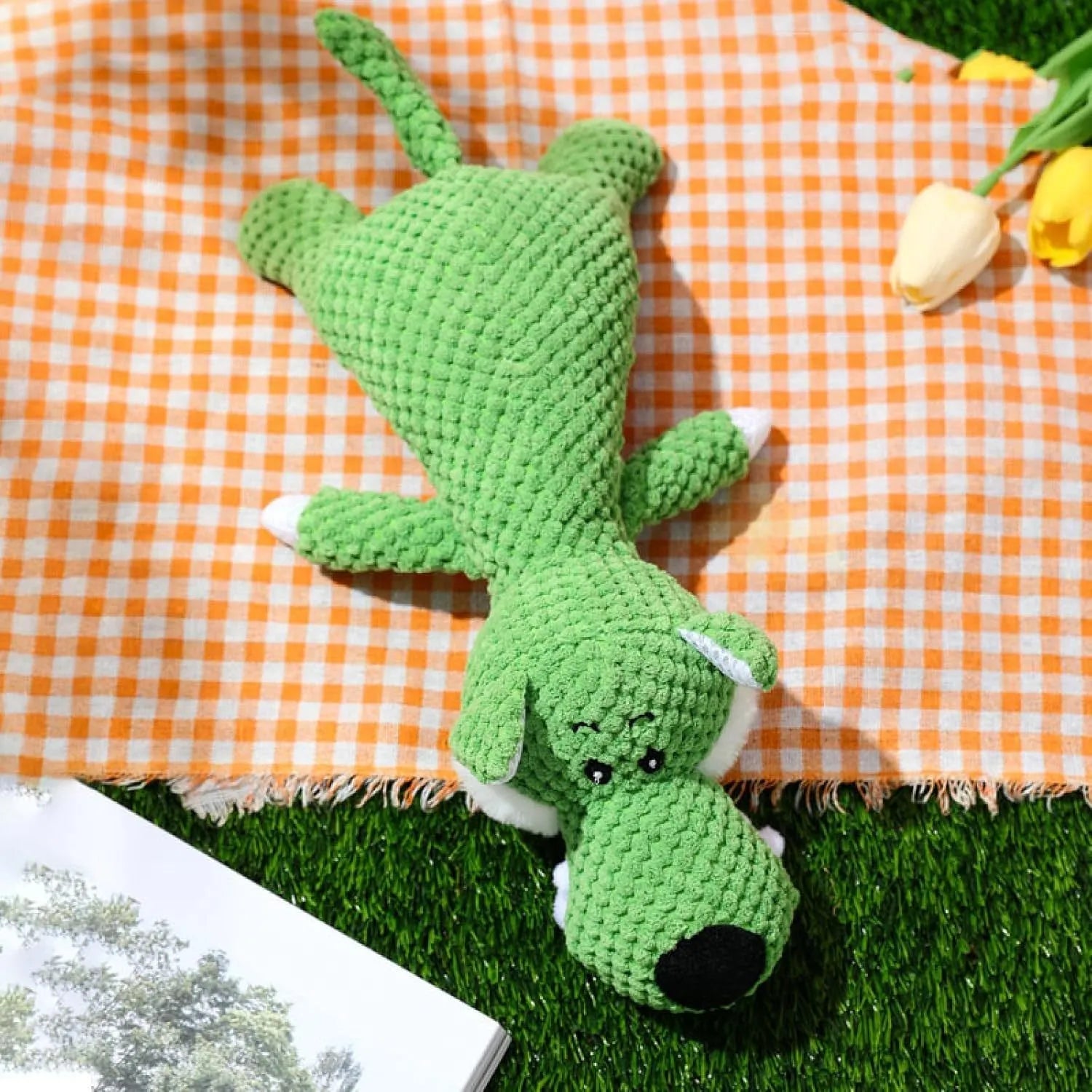 Green plush dog chew toy shaped like an animal with a corn kernel texture and a squeaker inside.