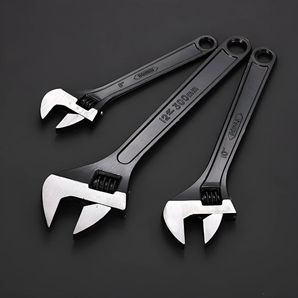 Blackened high-carbon steel adjustable open-end wrench with ergonomic handle on a workbench.