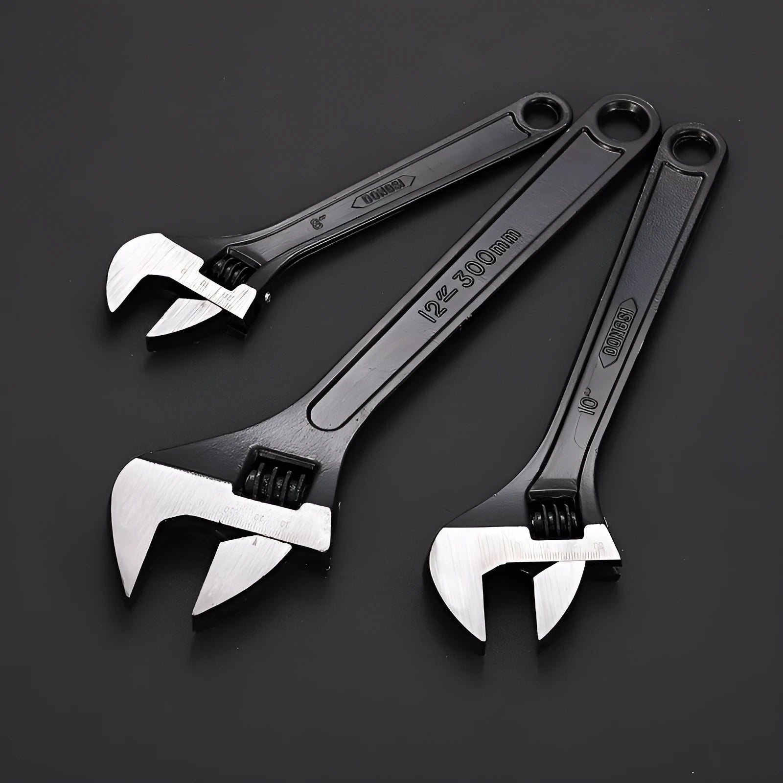 Blackened high-carbon steel adjustable open-end wrench with ergonomic handle on a workbench.