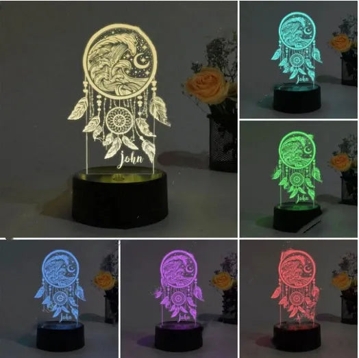 Dream catcher shaped acrylic night light with black base and colourful lighting on wooden surface