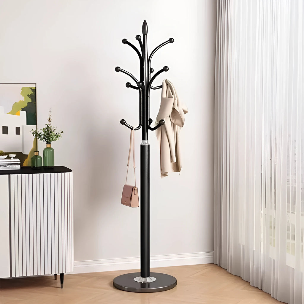 Floor-standing iron coat rack in black with vertical metal frame for hanging jackets and bags in a bedroom or hallway