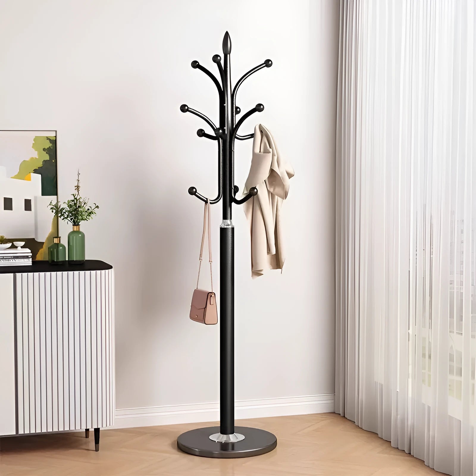 Floor-standing iron coat rack in black with vertical metal frame for hanging jackets and bags in a bedroom or hallway